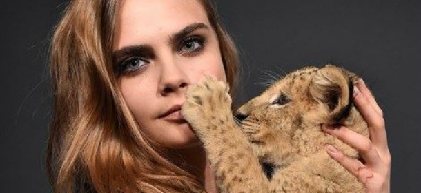 Cara Delevingne, nuova testimonial per Tag Heuer, sfila con un cucciolo di leone