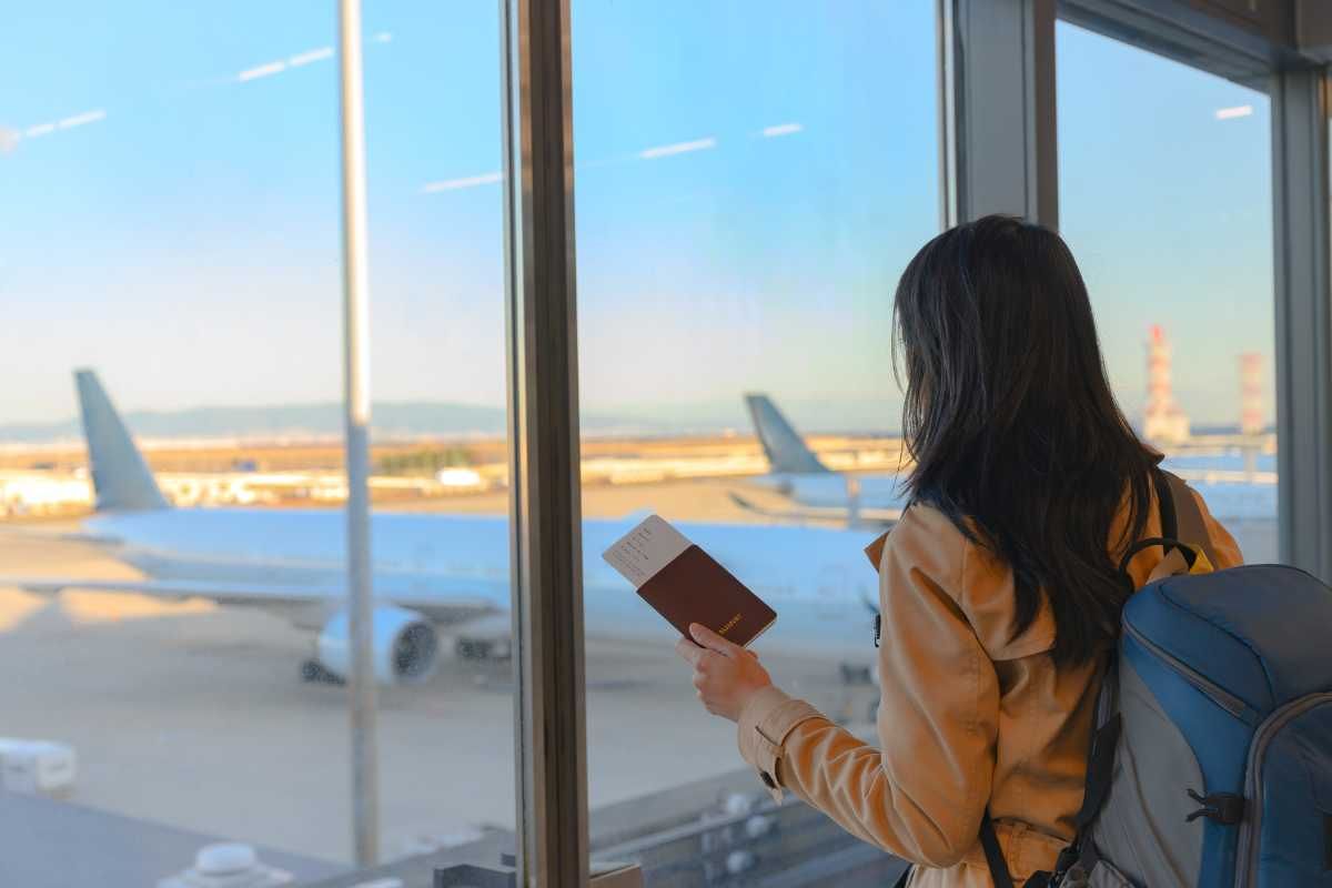 viaggiatrice in aeroporto con biglietto