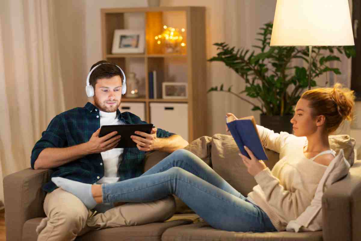 coppia legge e ascolta musica in un angolo relax a casa