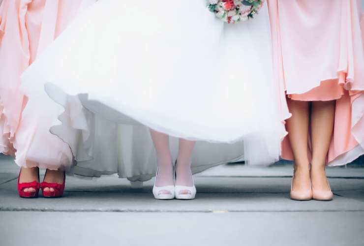 piedi e scarpe di una sposa e delle damigelle