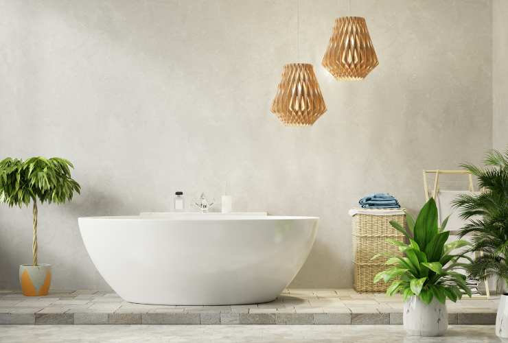 bagno con parete chiara, vasca di design e piante